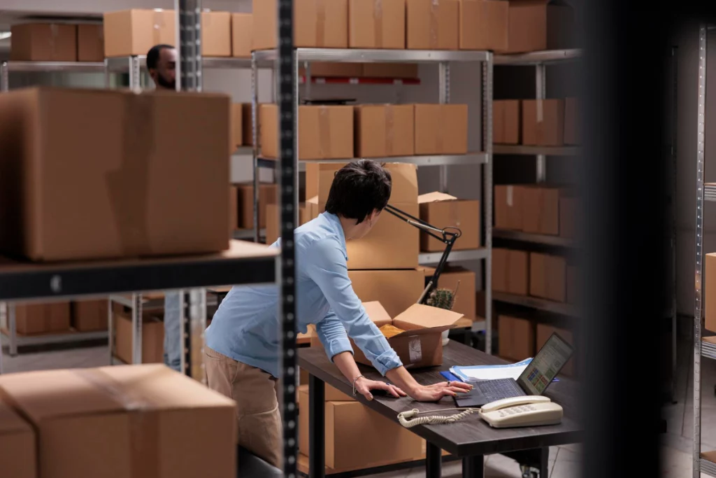 warehouse employee checking shipping details, before start packing clients orders putting clothes carton boxes preparing delivery woman working delivery department
